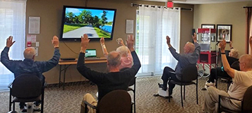 Residents at Cedarvale Lodge Retirement and Care Community in Georgina virtually cycle through Road Worlds for Seniors.
