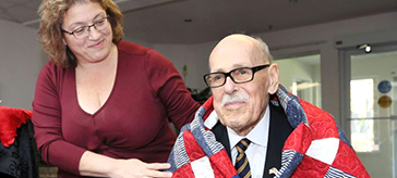 U.S. Army veteran William Moss, 89, receives a U.S. Quilt of Valor from Anna Donatucci during a ceremony at Windsor's Kensington Court Retirement Residence on Friday.