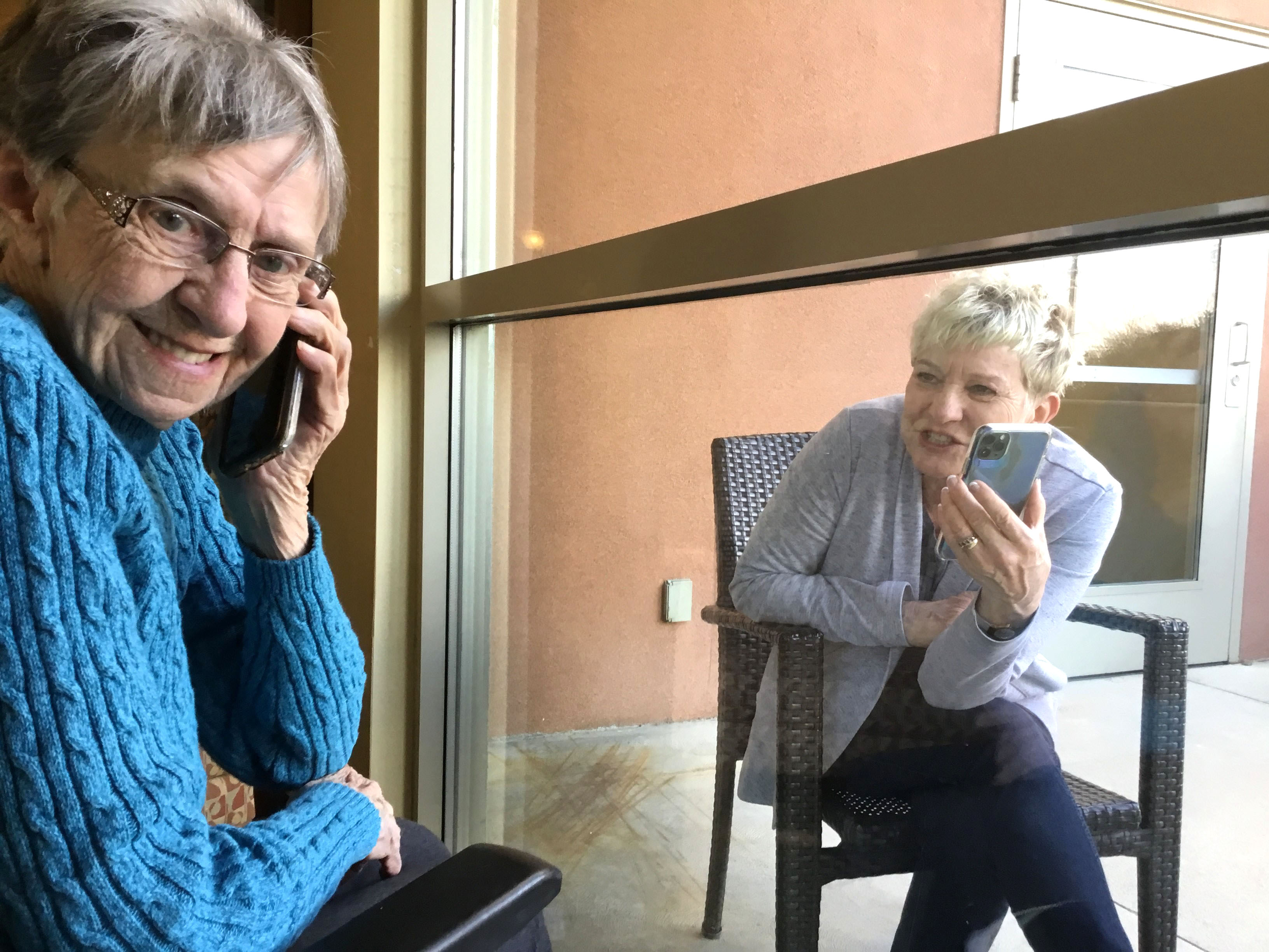 A resident having a window visit with her family member. 