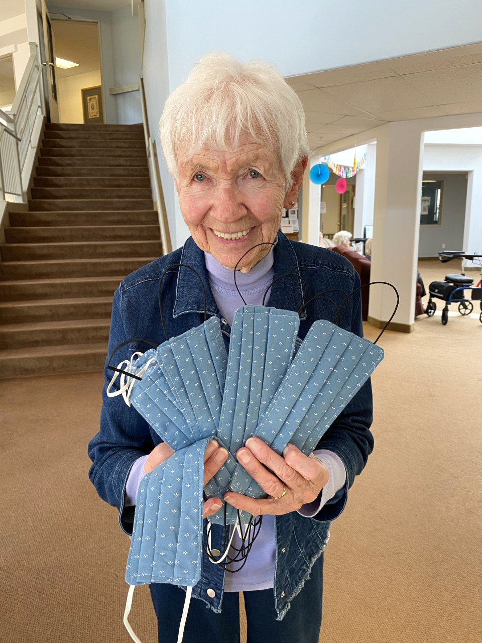 A resident holding face masks that she made to donate to the local hospital. 