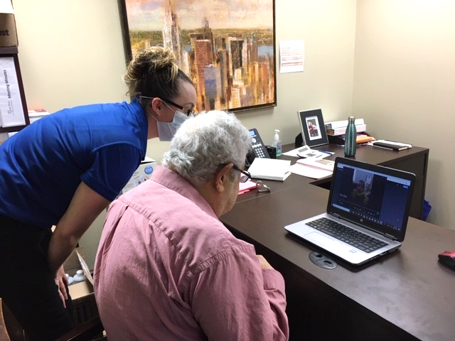 A resident and a staff member on the computer. 