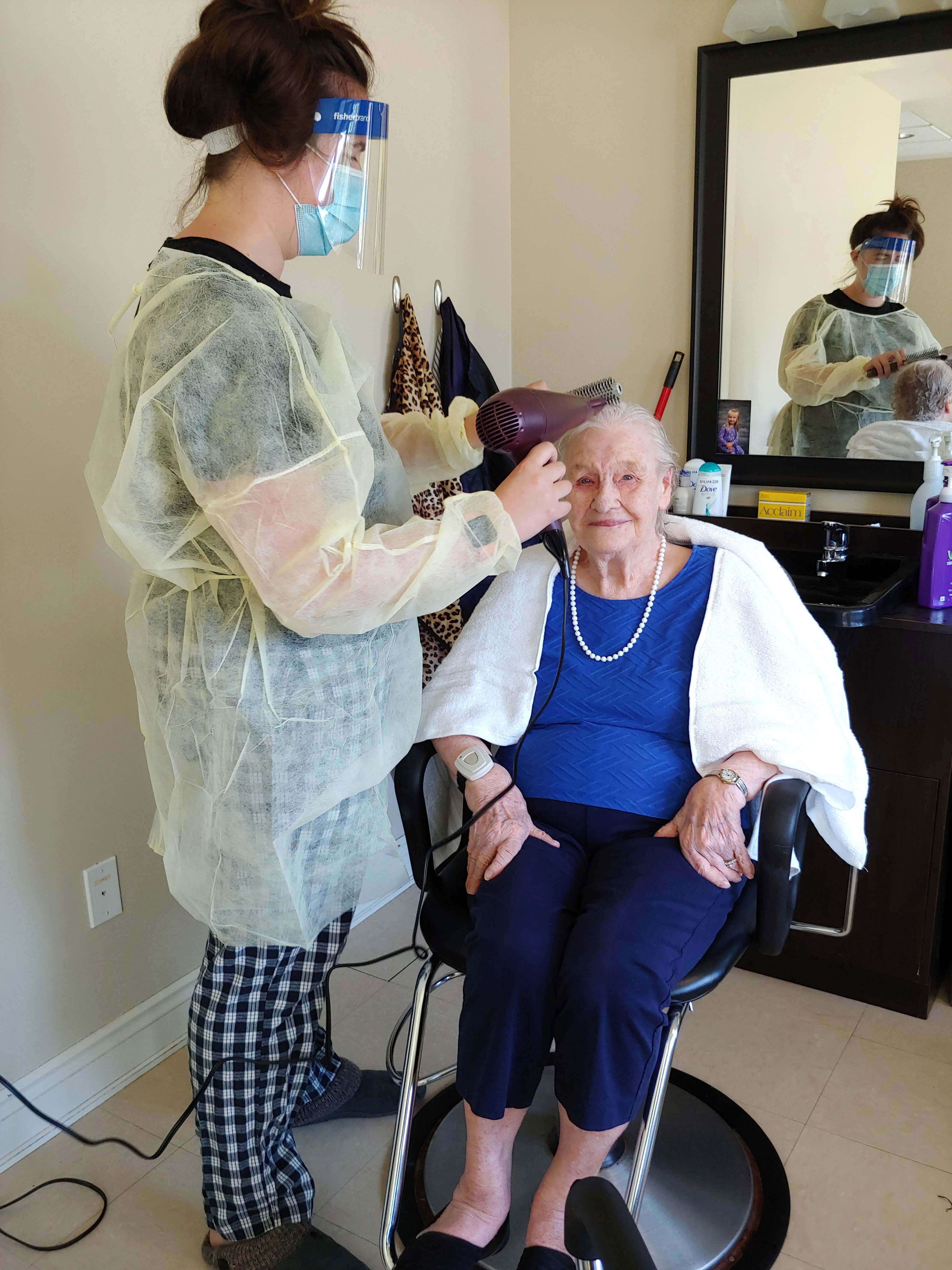 A team member giving a resident a hair cut. 