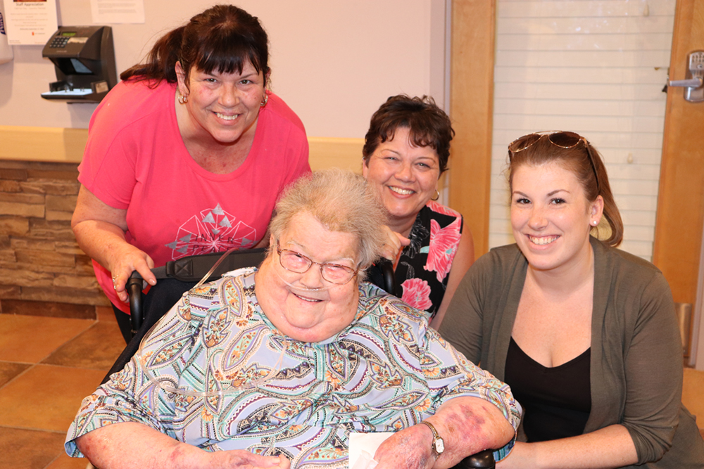 Group of three team members spending time with a resident. 