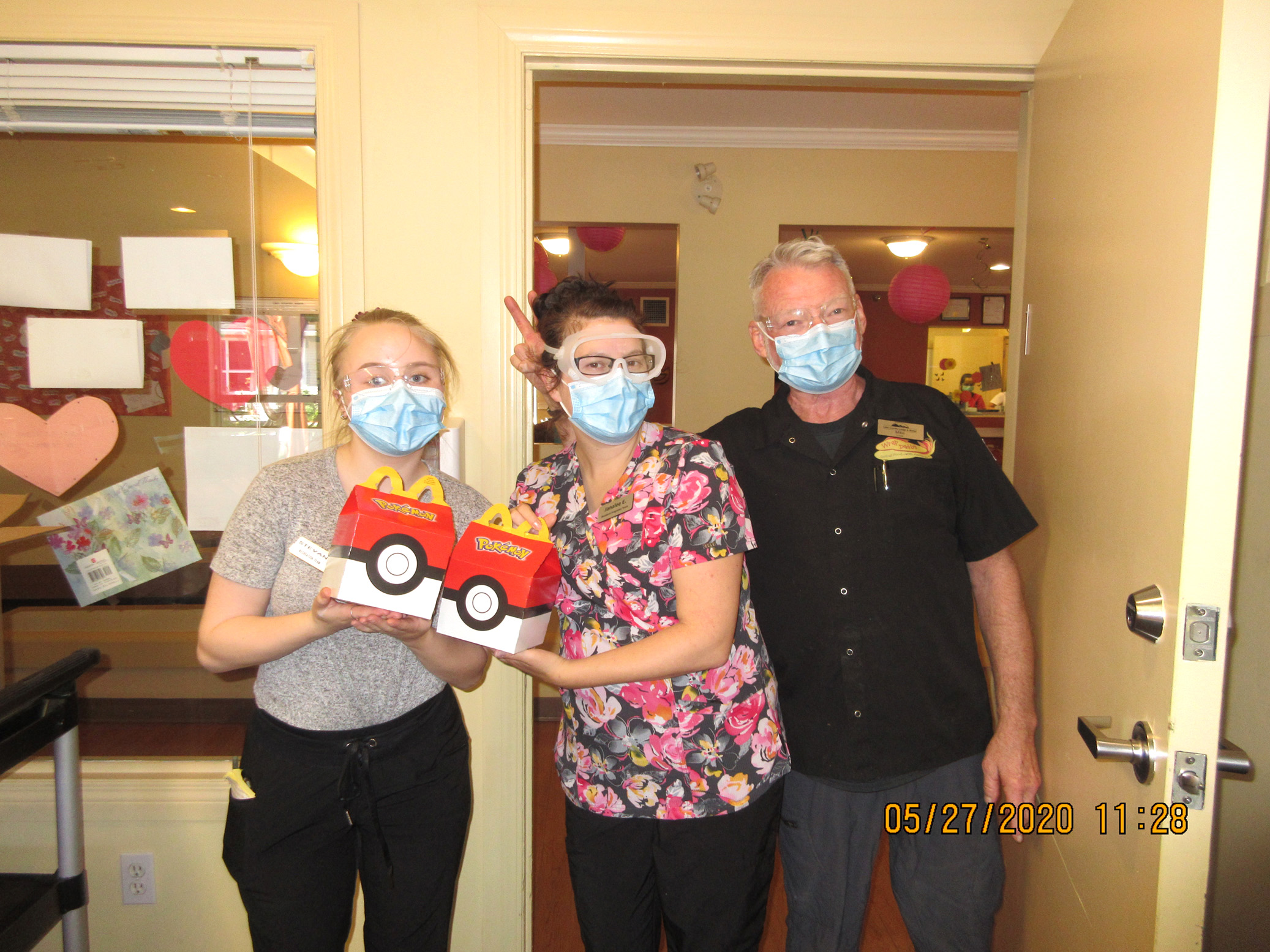 Team members holding McDonald’s Happy Meals. 