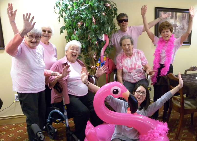 Team members and residents having a flamingo-themed party. 