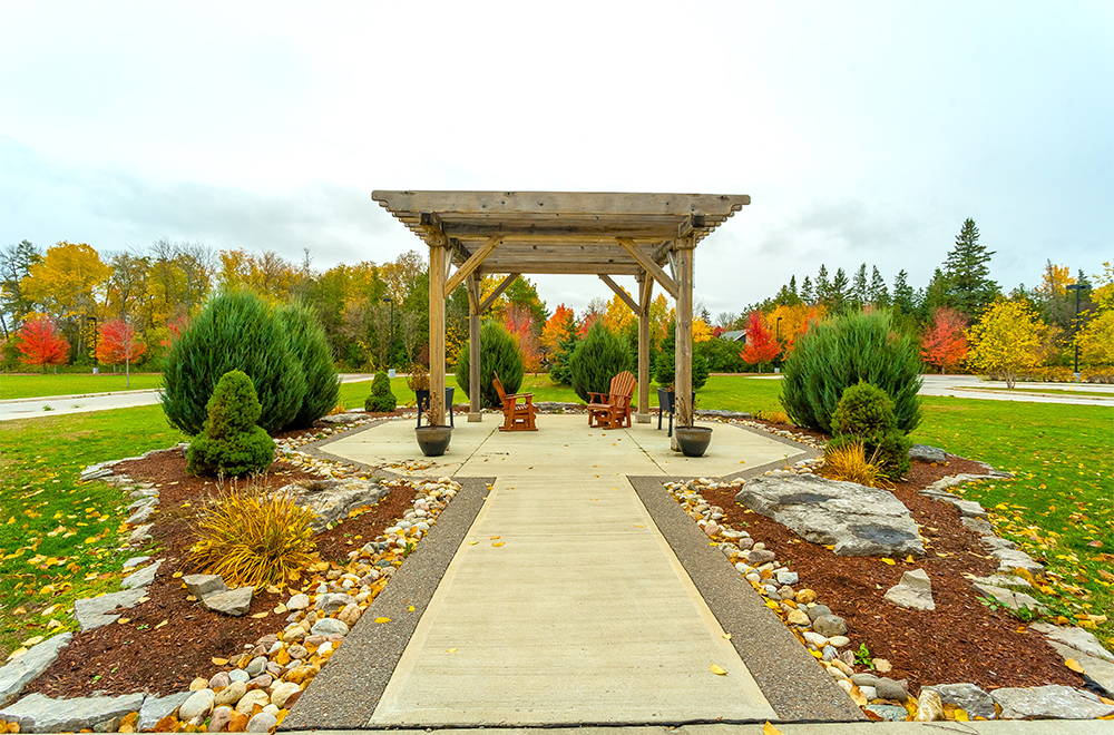 Outdoor seating area surrounded by beautiful garden at Kawartha Lakes Retirement Residence in Bobcaygeon