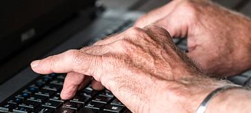 image of a senior typing on a laptop