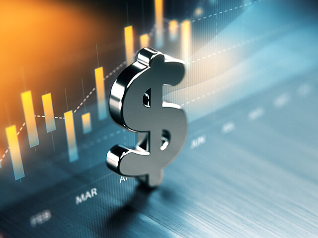 image of Canadian dollar symbol standing on wood surface in front of a graph.