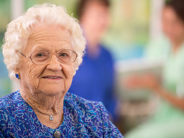 image of a senior woman using her hands to form a heart shape