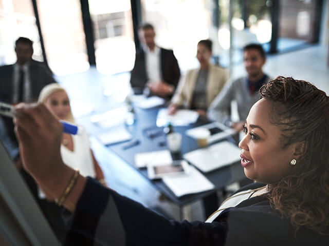 image of  a young businesswoman explaining work related stuff during a presentation to work colleagues in a boardroom