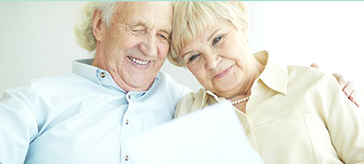 A senior couple looking at a piece of paper together and smiling