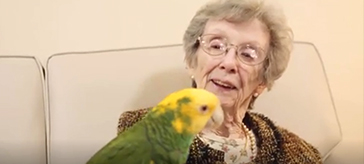 image of a female resident is having fun with the parrot.