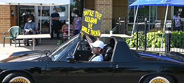 image of the tour of classic and late-model high-performance Porsche models passed by with drivers and passengers waiving to residents at Norfinch Care Community.
