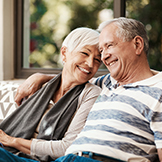 A happy senior couple laughing together in an outdoor area