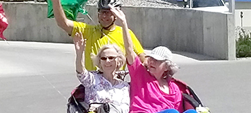 Photo of Cycling Without Age pilot Ward Strong (rear) takes two female seniors for a spin around the Schubert Centre.