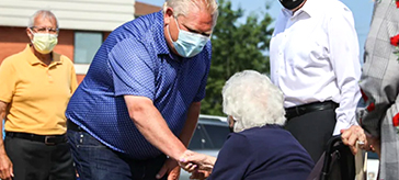 Premier Doug Ford shaking hand with one of the residents at Water's Edge Care Community long term care home. 