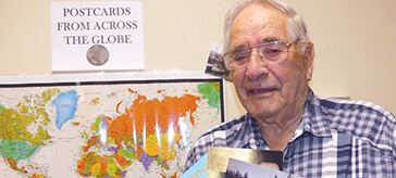 image of Bradford Valley Care Community resident Dennis Reed shows off some of the postcards the facility has received.