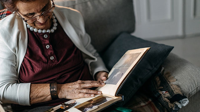 Elderly woman flips through photo album