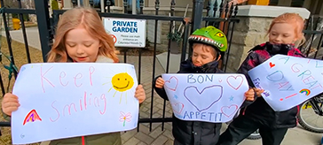image of 3 kids over to the Waterford Retirement Residence (Sienna Senior Living) with signs of positivity for them to read in the windows while they enjoyed their lunch to help lift their spirits.