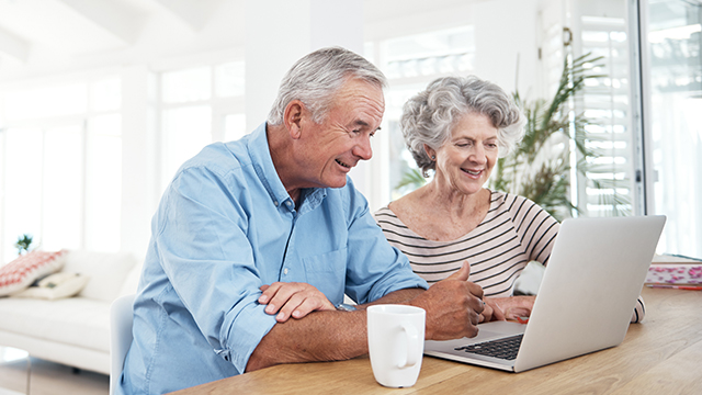 image of a senior couple looking at the laptop smiling