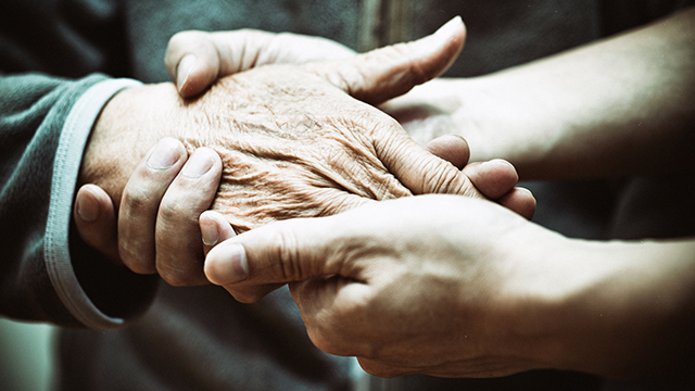 Elderly hand and caregiver