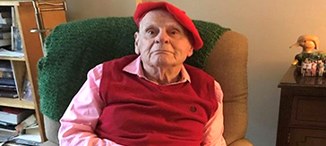 image of 86-year-old Bert Wilson sitting on a green sofa in an indoor setting